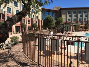 A decorative wrought iron pool fence secures a hotel's pool area.