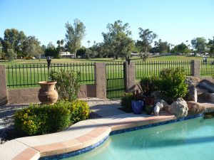Wrought iron fence encloses a pool area.