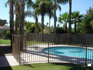 Wrought iron fencing encloses a residential pool.