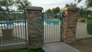 Turquoise-colored wrought iron pool fence and gate secure a community pool area.