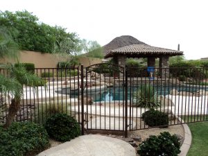 Wrought iron pool fence and gate secure a residential pool area.