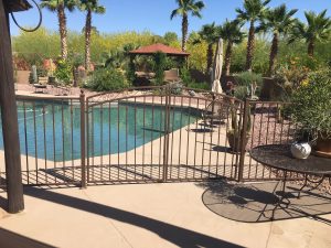 Bronze wrought iron pool gate enhances pool safety.