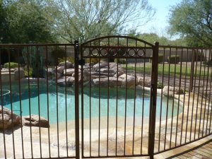 A custom wrought iron pool fence and gate secure a residential pool.